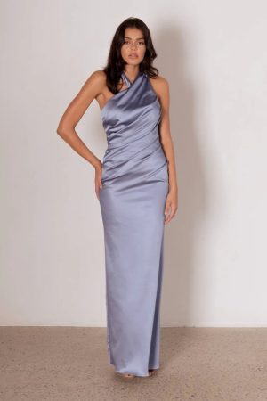 Model wearing the Xoey blue bridesmaid dress by Tania Olsen in stretch satin, featuring a twisted halter neckline, ruched bodice, and fitted silhouette with back split.