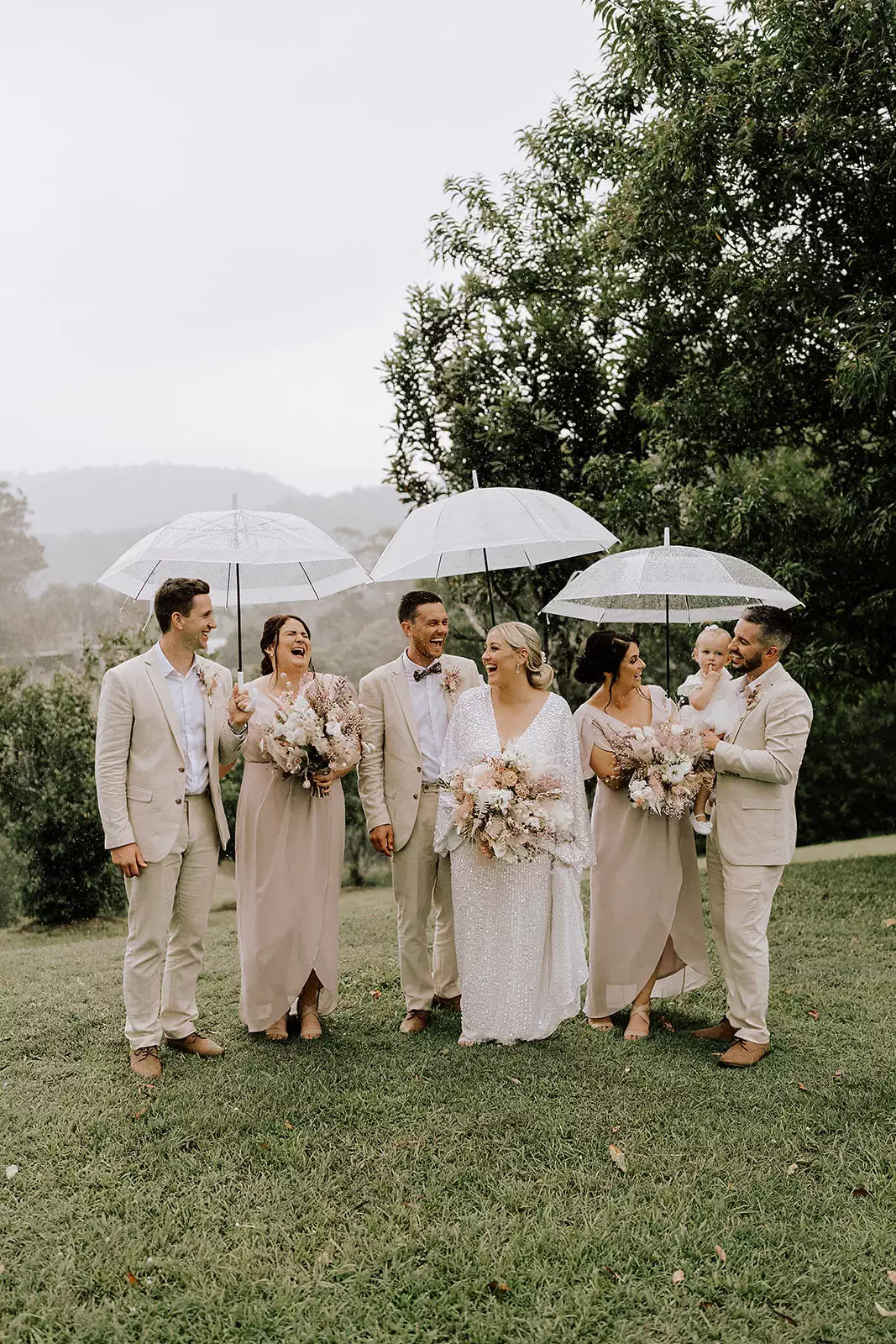 Real wedding bridal party — bride, groom and bridesmaids with clear umbrellas — Bridesmaids Only